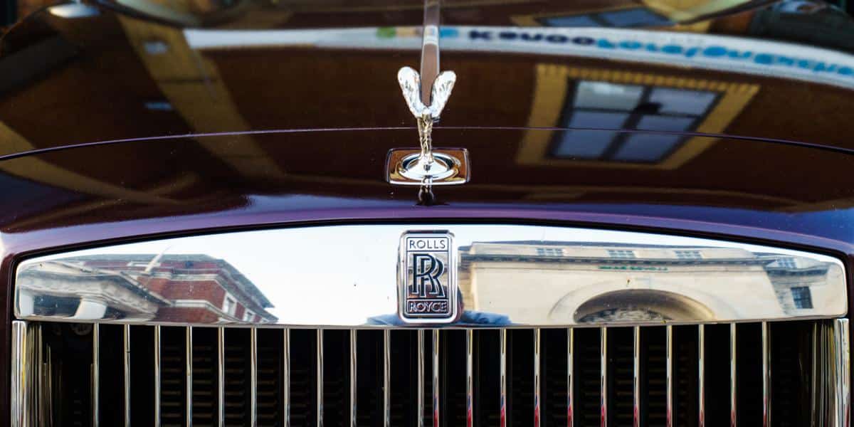 A detailed shot of the front grill and spirit of ecstasy emblem of a dark purple 2024 Rolls-Royce Phantom.