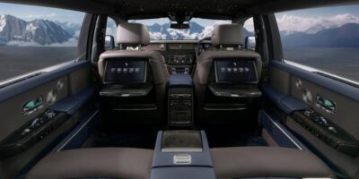 Luxurious Rolls Royce interior showcasing premium leather seats, starlight headliner, and rear seat screens in an elegant cabin setting.