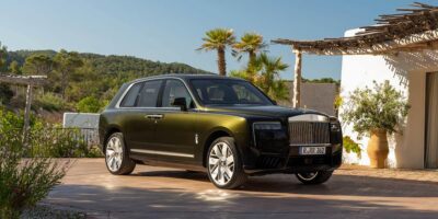 2026 Rolls Royce Cullinan luxury SUV in olive green parked at a modern villa with palm trees